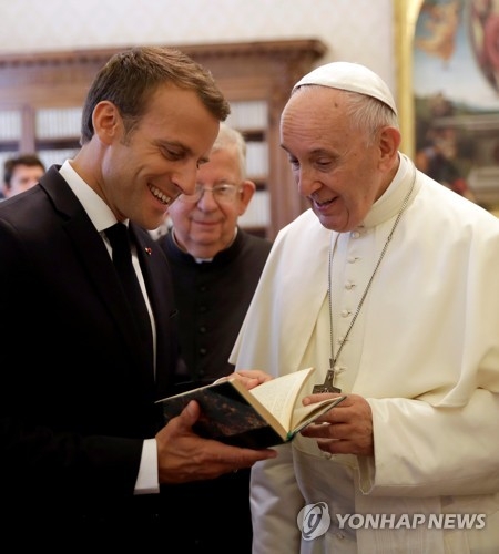 26일 프란치스코 교황과 선물을 주고받고 있는 에마뉘엘 마크롱 프랑스 대통령(왼쪽) [로이터=연합뉴스] 