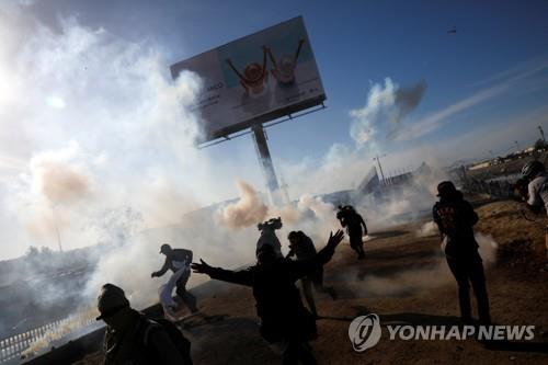 미국 국경순찰대의 최루가스에 저지당하는 이민자들[로이터=연합뉴스]