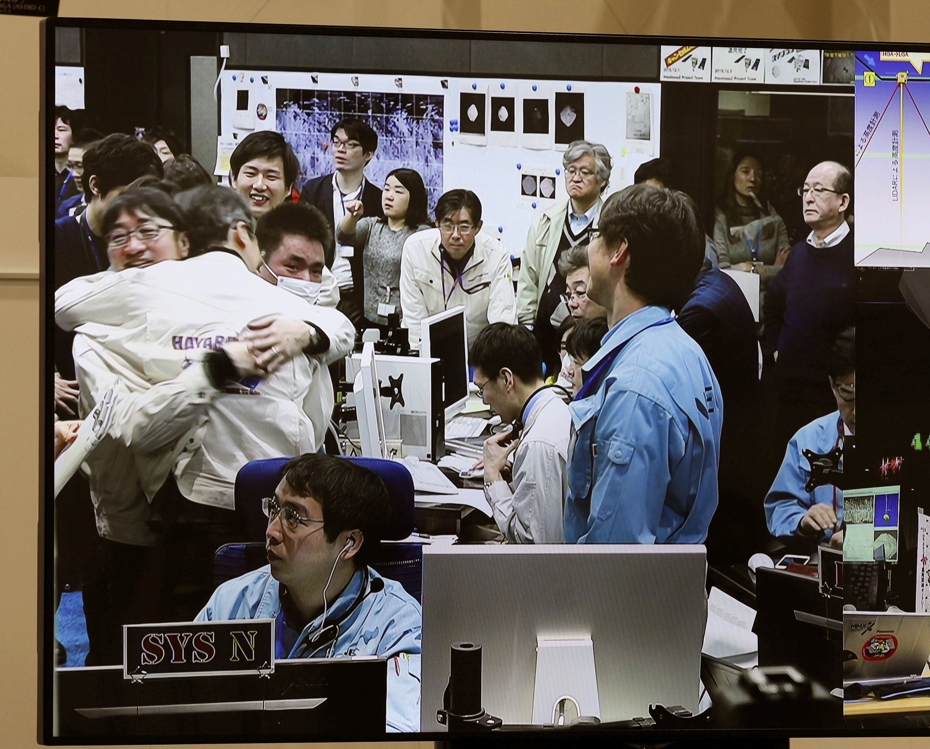 JAXA 프로젝트팀원들이 하야부사2의 '류구' 착륙 성공 판단이 나온 뒤 서로 부둥켜안고 기뻐하고 있다. [교도=연합뉴스]