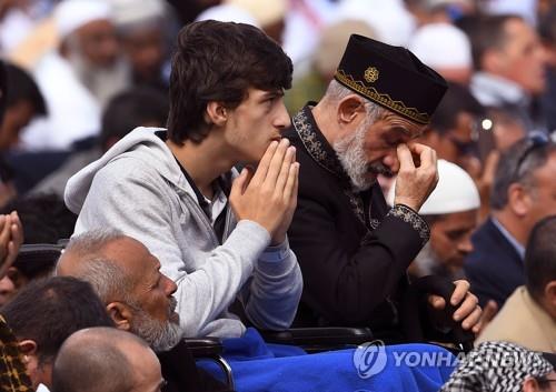 22일 뉴질랜드 크라이스트처치에서 열린 기도회에서 사람들이 모스크 테러 사건 희생자들을 위해 기도하고 있다. [AFP=연합뉴스]