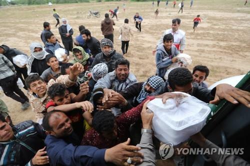 이란 후제스탄 주에서 이재민들이 구호품을 받고 있다