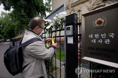 30일(현지시간) 헝가리 부다페스트 한국대사관의 철문에 노란 리본을 달고 있는 추모객[AFP=연합뉴스]