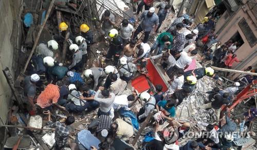 16일 인도 뭄바이의 무너진 건물에서 잔해에 깔린 생존자를 수색하는 구조팀. [로이터=연합뉴스]