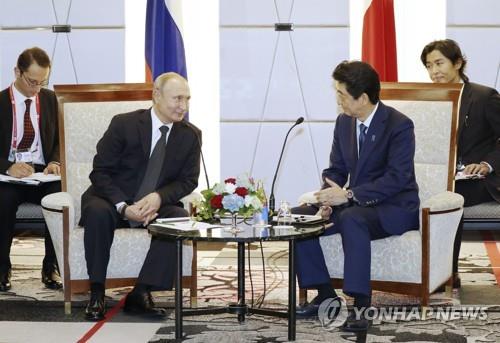 지난 6월 29일 오사카에서 열린 주요 20개국(G20) 정상회의 때 블라디미르 푸틴 러시아 대통령(왼쪽)이 아베 신조 총리를 만나 회담하고 있다. [교도=연합뉴스 자료사진]