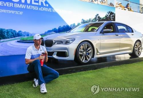 BWM 승용차 앞에 앉아 있는 로리 매킬로이.