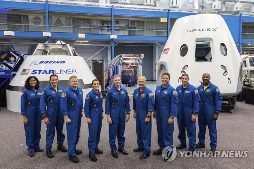 크루 드래건과 스타라이너 앞에서 포즈를 취한 NASA 우주인들 
