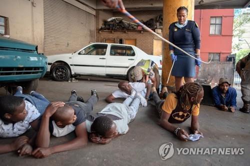 봉쇄령 첫날인 27일 술을 갖고 있다 경찰에 체포된 사람들이 바닥에 누워있다. 