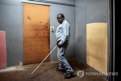 짐바브웨에서 남아공에 이주한 시각장애인 제트로 고네세씨가 지난 22일 걷고 있다.