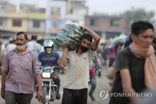 인도 잠무에서 마스크를 쓰고 야채를 옮기는 남성. [AP=연합뉴스]
