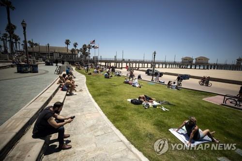 독립기념일인 4일(현지시간) 미 캘리포니아주 헌팅턴비치에서 해변이 폐쇄되자 사람들이 해변 인근의 잔디밭에 누워 일광욕을 하고 있다. [EPA=연합뉴스]