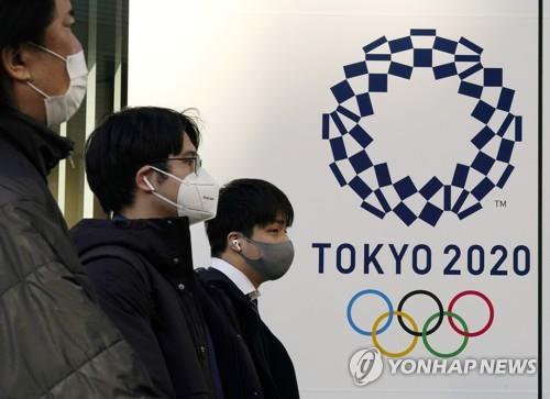 (도쿄 EPA=연합뉴스) 일본에 신종 코로나바이러스 감염증(코로나19) 긴급사태가 발령 중인 가운데 지난달 21일 도쿄에 설치된 올림픽 홍보물 근처에서 마스크를 쓴 사람들이 이동하고 있다.