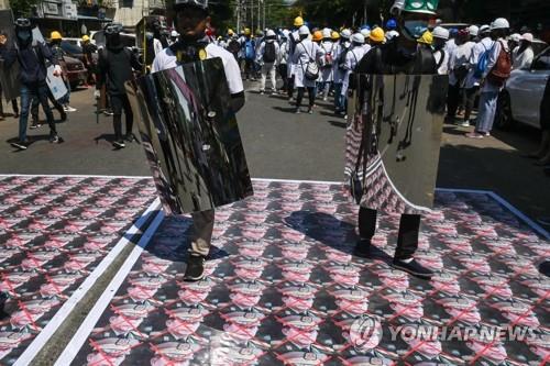 5일 군부 쿠데타 주역의 초상화를 짓밟는 미얀마 시위대. [AFP=연합뉴스]