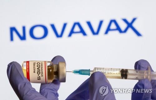 미국 제약사 노바백스 로고 앞에서 백신 접종을 준비하는 모습