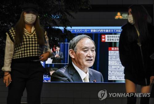 (도쿄 EPA=연합뉴스) 4월 23일 오후 일본 도쿄도(東京都) 신주쿠(新宿)구에 설치된 대형 스크린에 스가 요시히데(菅義偉) 일본 총리가 신종 코로나바이러스 감염증(코로나19) 긴급사태와 관련한 기자회견을 하는 모습이 중계되고 있다.
