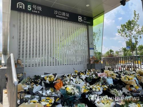 27일 中허난성 정저우 사고 지하철 입구에 놓인 추모 꽃다발
