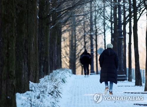 눈 쌓인 공원 걷는 시민들