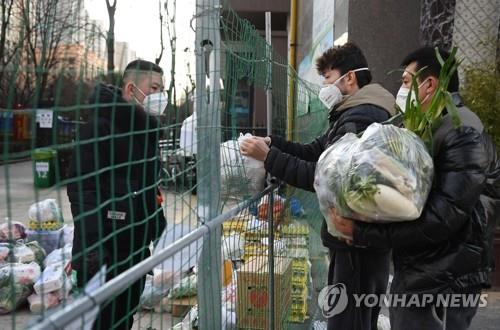 中 시안서 주민용 생필품 건네받는 자원봉사자