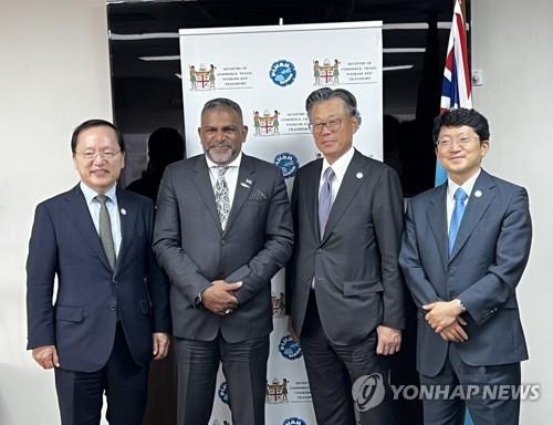 Cho Dae-sik (segundo por la dcha.), jefe del Consejo Supex del Grupo SK, el máximo órgano de toma de decisiones del conglomerado, y otros representantes de la firma se toman una foto con el ministro de Comercio de Fiyi, Faiyaz Siddiq Koya (segundo por la izda.), luego de una reunión al margen del Foro de las Islas del Pacífico, realizado, el 12 de julio de 2022, en la nación insular. (Foto proporcionada por SK. Prohibida su reventa y archivo)