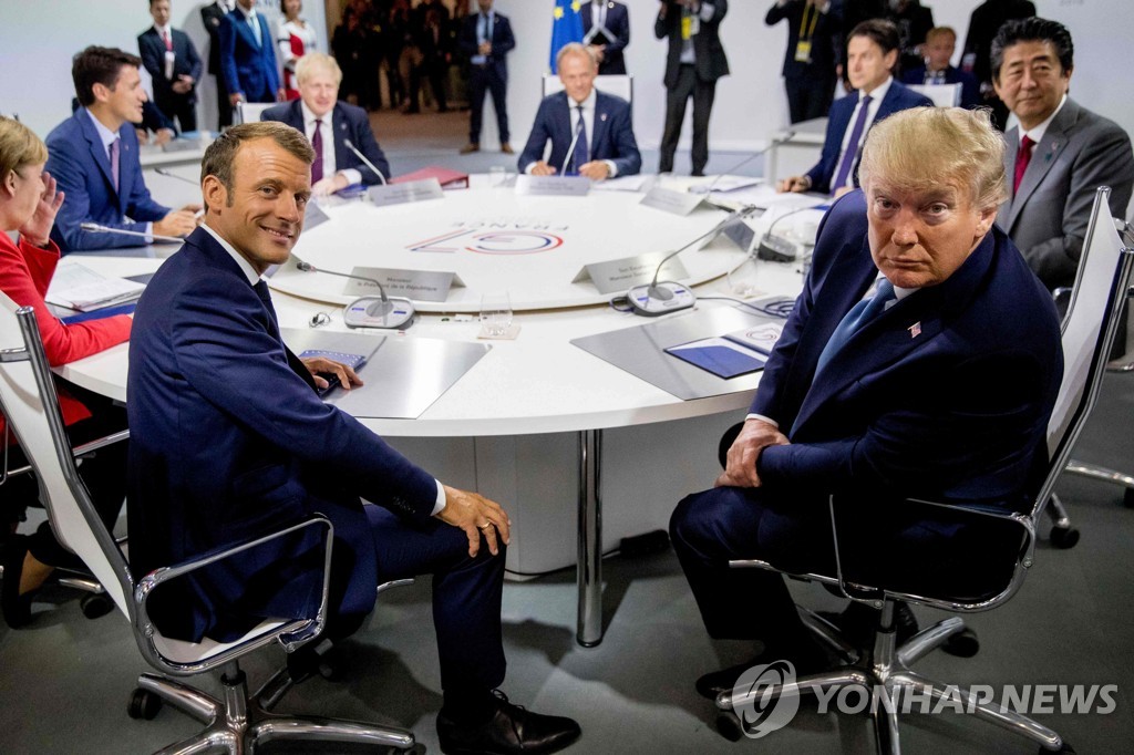 25일 프랑스 비아리츠에서 열린 G7 정상회담에 모인 지도자들. 에마뉘엘 마크롱 프랑스 대통령(앞줄 왼쪽)과 도널드 트럼프 미국 대통령(앞줄 오른쪽)이 취재진의 카메라를 바라보고 있다. [AFP=연합뉴스]