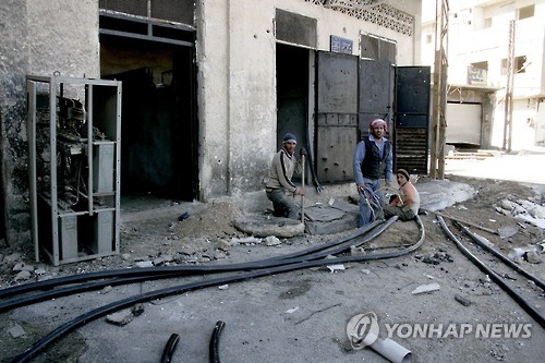 다마스쿠스 외곽에서 파손된 전기설비를 손보는 시리아인들