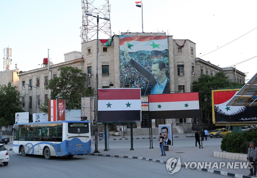 아사드 대통령의 사진과 국기가 걸린 시리아 북부 알레포 거리