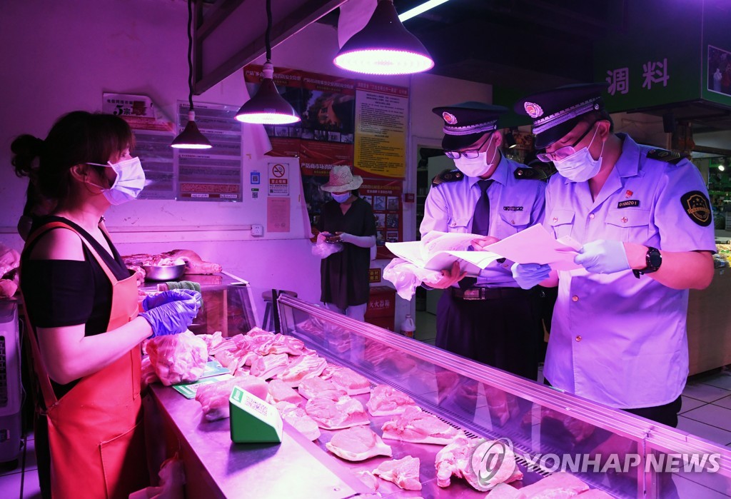 베이징의 한 시장에서 감독당국 직원들이 육류를 확인하고 있다. [신화=연합뉴스 자료사진]