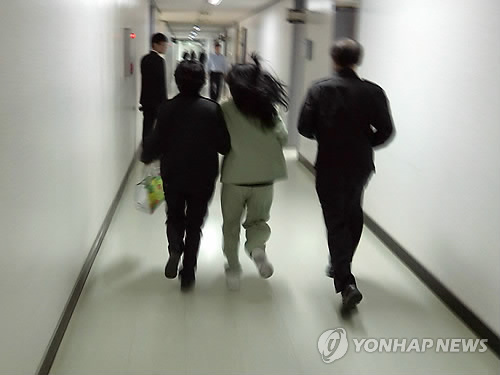 의붓딸을 숨지게 한 혐의로 구속기소된 계모 임모씨가 지난해 4월 취재진을 피해 법정으로 가고 있다. <<연합뉴스DB>>