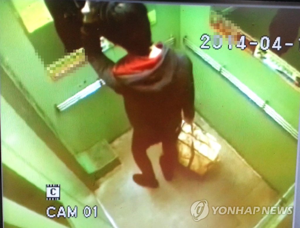 쓰레기 봉투에 생후 28개월된 아들을 버린 정모(22)씨가 숨진 아이가 든 것으로 보이는 봉투를 들고 집을 나서는 모습. CCTV 화면 캡쳐.