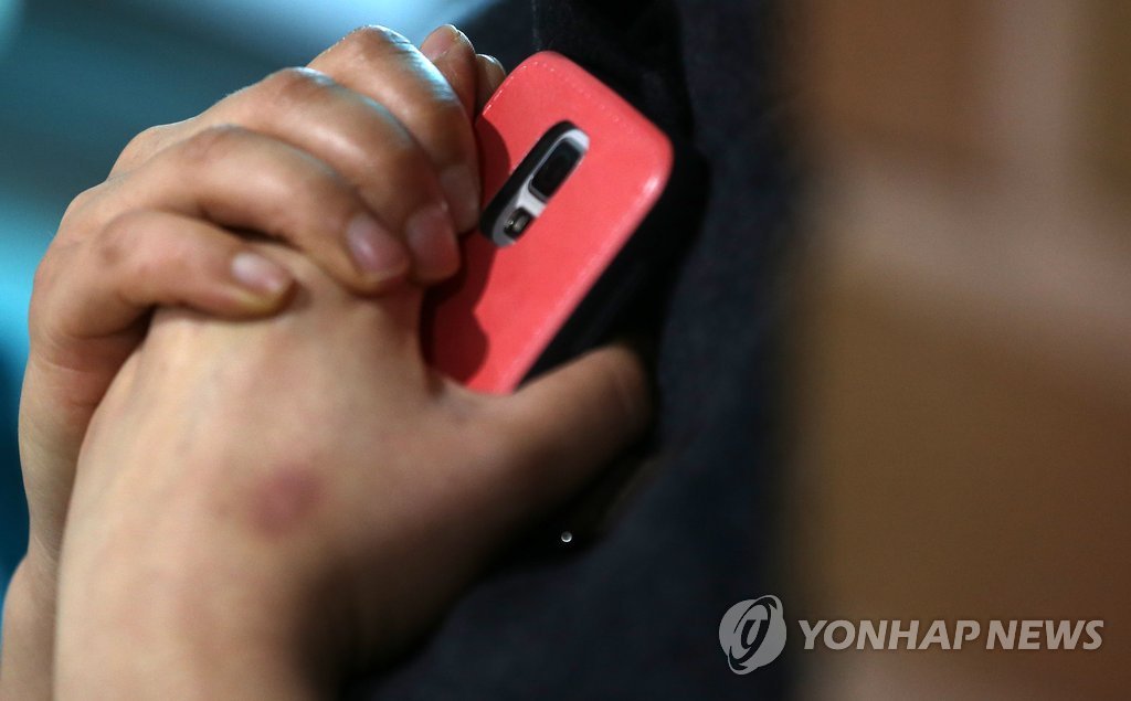 사고당일인 16일 오전 경기도 안산 단원고등학교에서 한 학부형이 휴대전화를 움켜쥐고 빨리 자식의 연락이 오길 기다리고 있다.