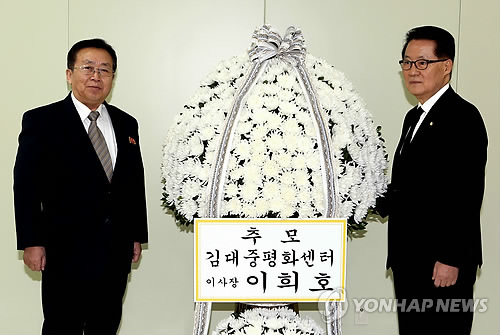 북한 김정일 국방위원장 사망 3주기를 맞아 고(故) 김대중 전 대통령의 부인인 이희호 여사 명의의 조화를 지난 16일 개성공단에서 새정치민주연합 박지원 의원(오른쪽)이 원동연 조선아시아태평양평화위원회 부위원장에게 전달하고 있다.