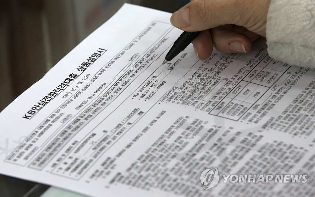 '안심전환대출'이 출시된 24일 오전 서울 여의도 KB은행 본점에서 안심전환대출 가입 희망자가 상품설명서에 개인정보를 기입하고 있다.
