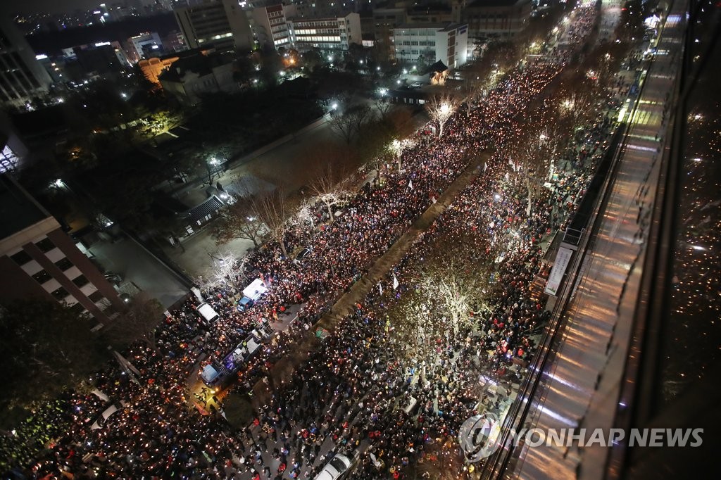 박근혜 대통령 퇴진 촉구 8차 촛불집회가 열린 지난 17일 서울 안국역 인근에서 참가자들이 촛불을 들고 있다. [연합뉴스 자료사진]