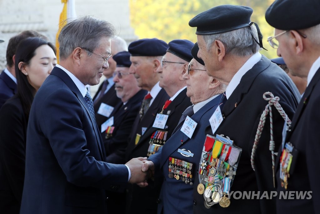 South Korean President Moon Jae-in (L) shakes hands with a French Korean War veteran during an official welcome ceremony held in Paris on Oct. 15, 2018 to mark his four-day state visit to France. (Yonhap)