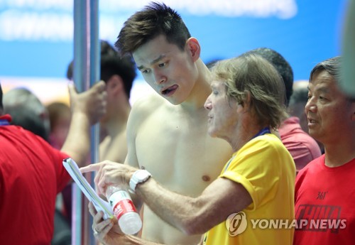 Chinese swimmer Sun Yang (C) speaks with his coach Denis Cotterell before the start of his training for the FINA World Championships at Nambu University Municipal Aquatics Center in Gwangju, 330 kilometers south of Seoul, on July 17, 2019. (Yonhap)