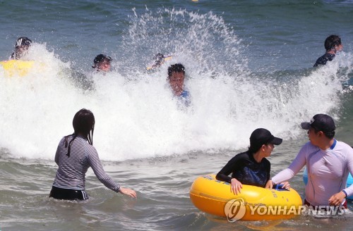 본격적인 폭염, 파도에 몸을 맡긴 피서객