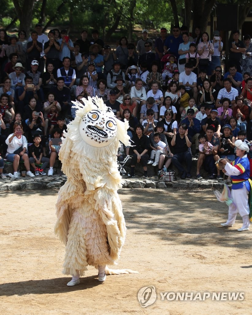 Spectators watch lion dance at folk village Spectators watch lion dance at folk village
