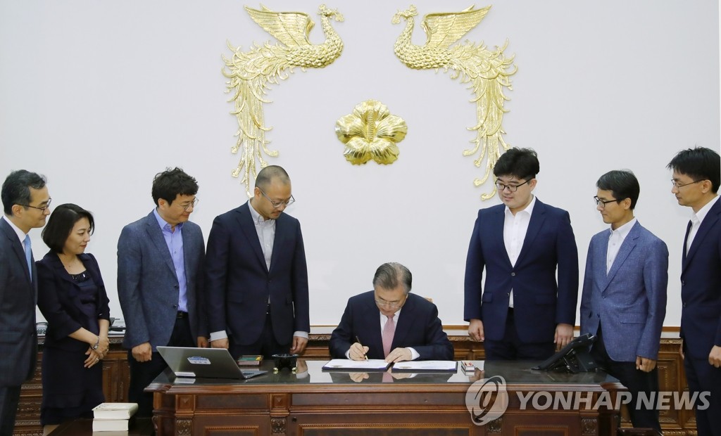 200만호 특허증 및 100만호 디자인등록증에 서명하는 문 대통령