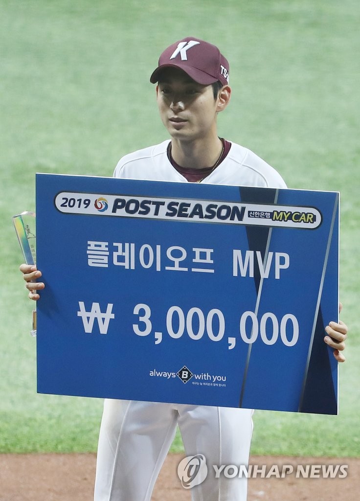 Lee Jung-hoo of the Kiwoom Heroes holds up the trophy and the oversize check after winning the MVP award for the second round Korea Baseball Organization playoff series, following the Heroes' 10-1 win over the SK Wyverns at Gocheok Sky Dome in Seoul on Oct. 17, 2019. (Yonhap)