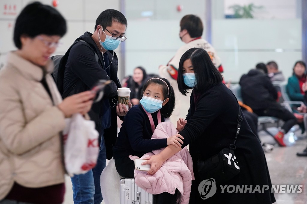 마스크 쓴 채 공항서 대기하는 중국 여행객들
