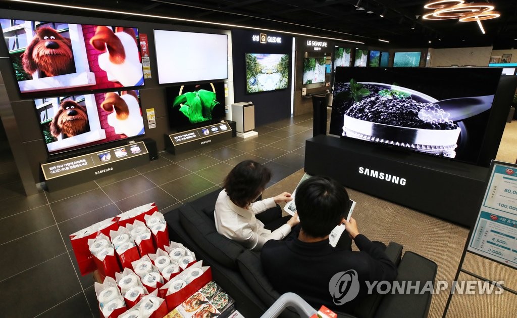 This file photo taken April 29, 2020, shows customers at a TV store in Seoul. (Yonhap)