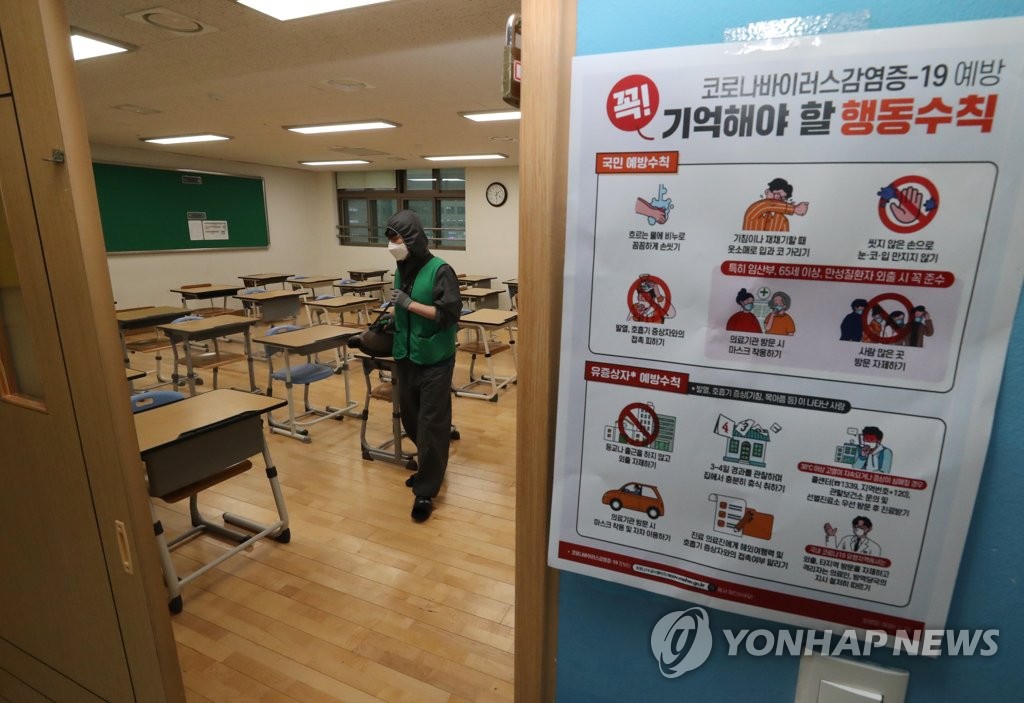 A quarantine official disinfects a classroom in a high school in the administrative city of Sejong on May 18, 2020. (Yonhap)