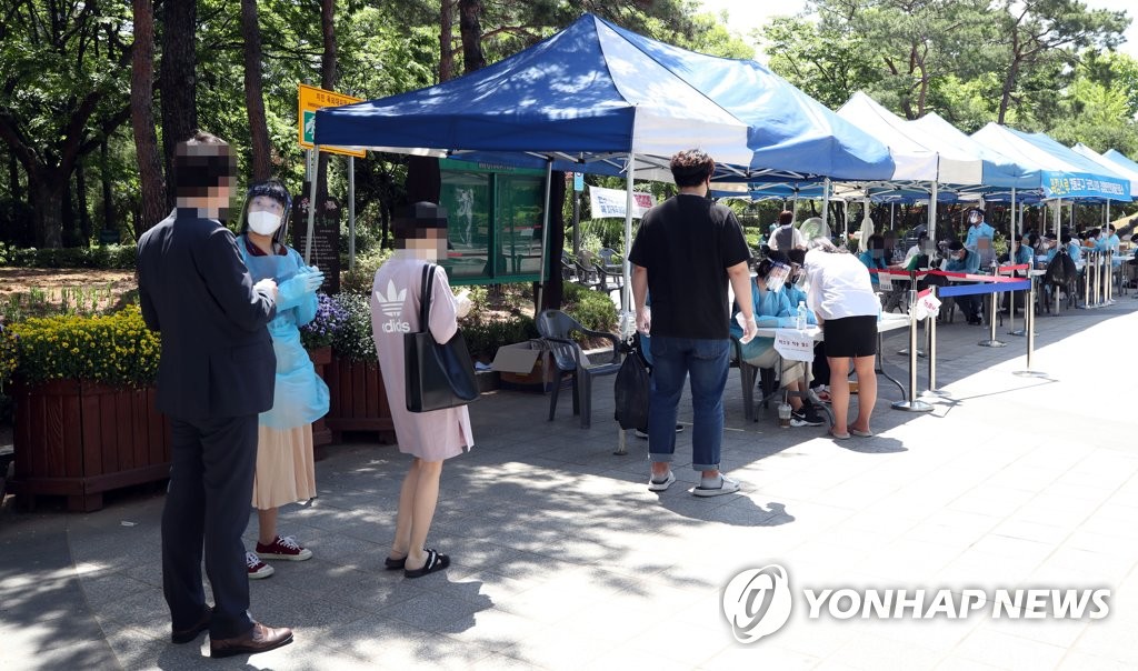 People line up to get tested for the new coronavirus at a walk-thru testing site at a park in Seoul on June 1, 2020. (Yonhap)