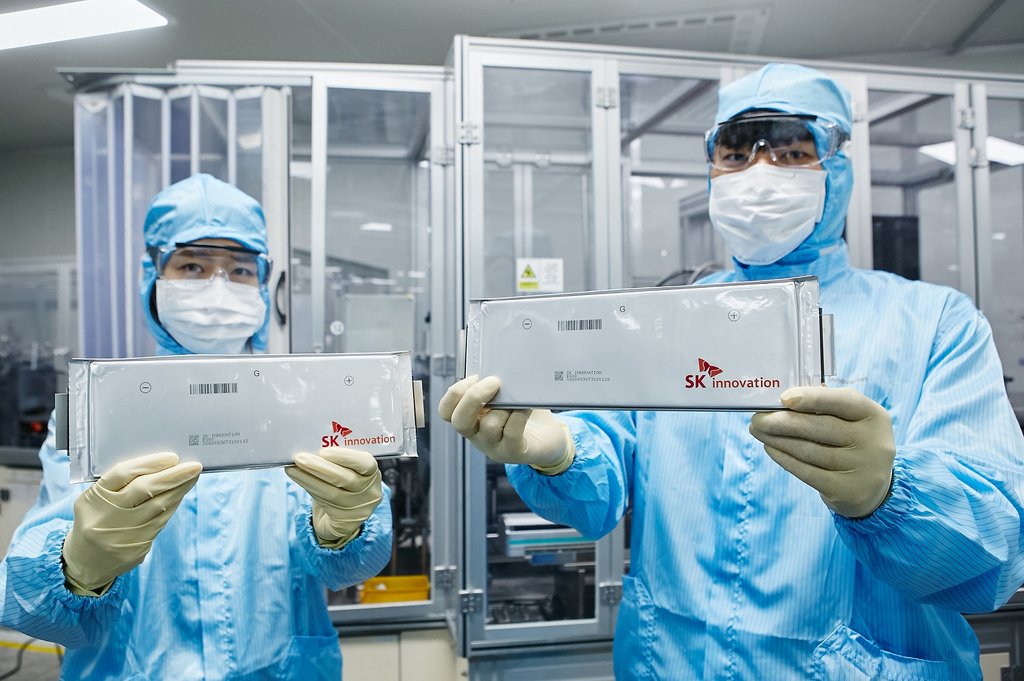 Employees of SK Innovation Co. present lithium-ion batteries for electric vehicles in this photo provided by the refinery-to-battery maker on July 30, 2020. (PHOTO NOT FOR SALE) (Yonhap)