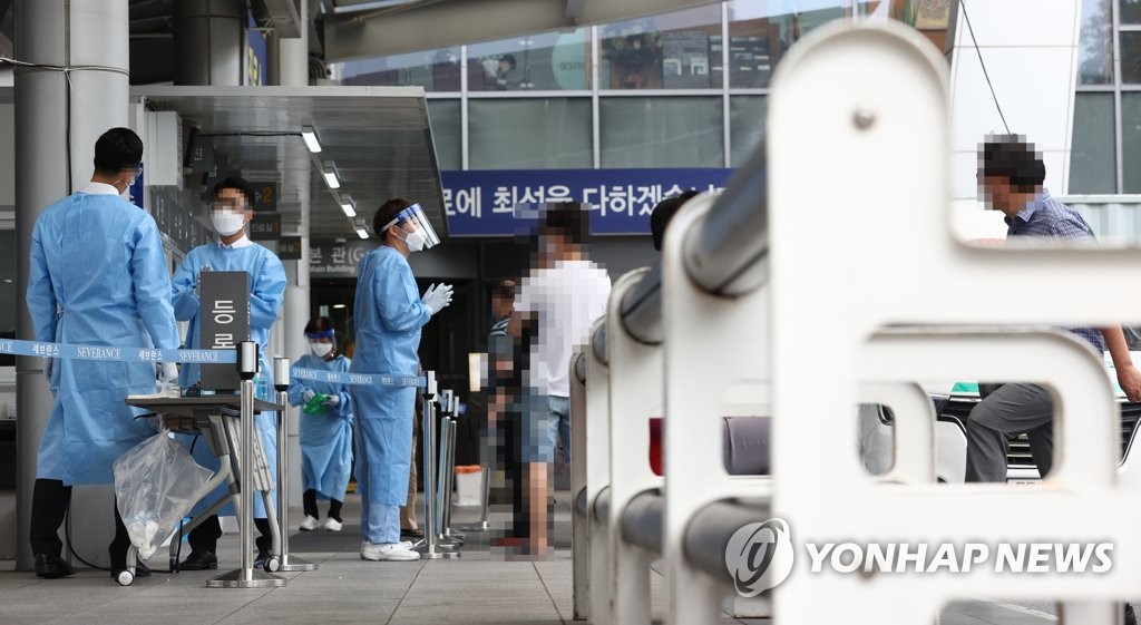 Medical staff and health officials talk to visitors at a treatment booth stationed at Yonsei Severance Hospital in Seoul on Sept. 17, 2020. (Yonhap) 