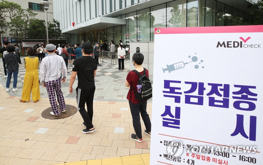독감 예방접종 받기 위해 줄 선 시민들