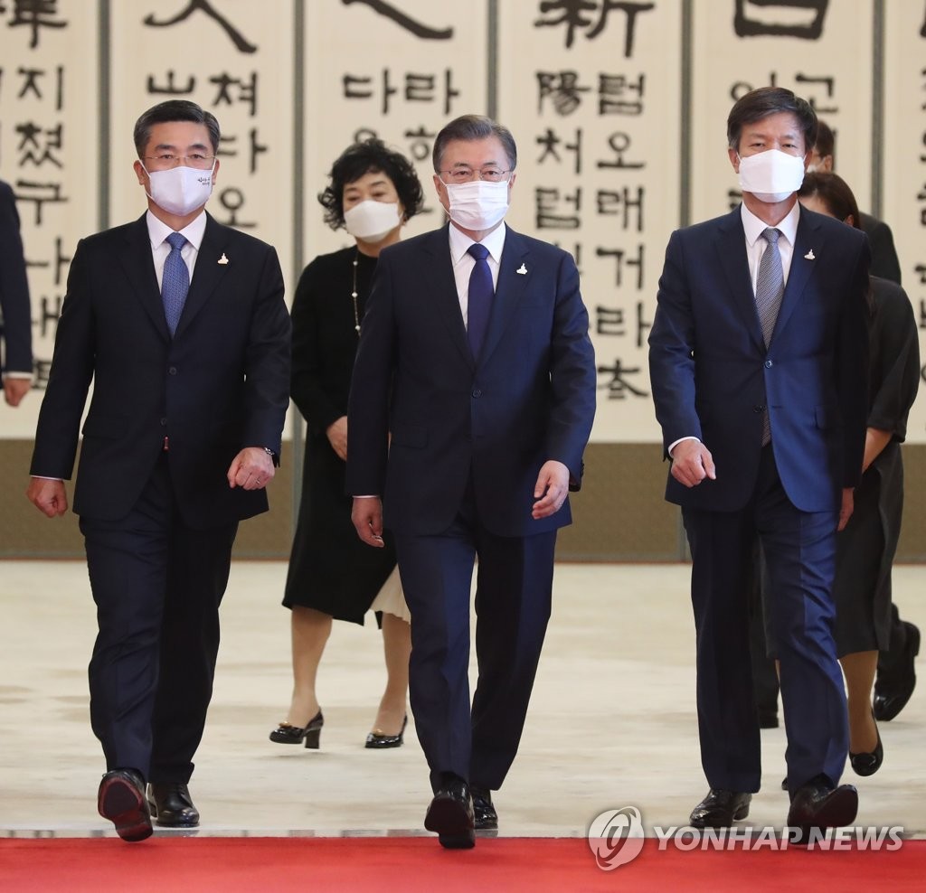 President Moon Jae-in (C) walks toward a Cheong Wa Dae room to converse with Defense Minister Suh Wook (L) and the National Tax Service Commissioner after presenting them with certificates of appointment on Sept. 18, 2020. (Yonhap) 