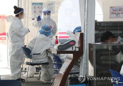 Medical workers carry out new coronavirus tests at a makeshift clinic in southern Seoul on Oct. 20, 2020. (Yonhap)