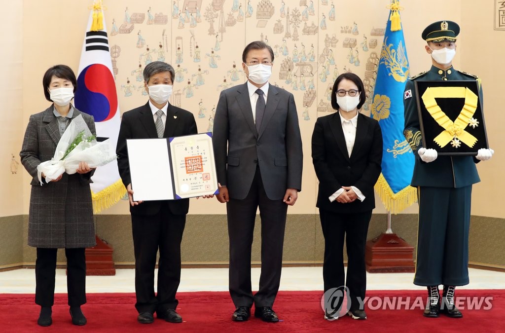 President Moon Jae-in (C) poses with family members of the late labor activist Chun Tae-il after posthumously conferring on him the Mugunghwa Medal of the Order of Civil Merit during a ceremony at Cheong Wa Dae in Seoul on Nov. 12, 2020. Flanking Moon from left to right are Chun's younger sister, Tae-ri, younger brother, Tae-sam, and younger sister, Soon-ok. (Yonhap)