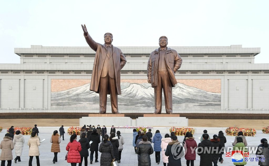 In this file photo, released by North Korea's official Korean Central News Agency on Feb. 17, 2021, North Korean citizens offer flowers in front of the statues of late national leaders Kim Il-sung and Kim Jong-il at Mansudae hill in Pyongyang the previous day to mark the birthday of the late leader Kim Jong-il, current leader Kim Jong-un's father. (For Use Only in the Republic of Korea. No Redistribution) (Yonhap) 