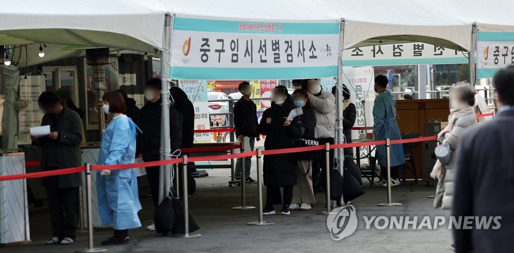 People wait in line to receive new coronavirus tests at a temporary testing site set up in front of Seoul Station in central Seoul on March 7, 2021. South Korea reported 416 more COVID-19 cases, raising the total caseload to 92,471. (Yonhap)